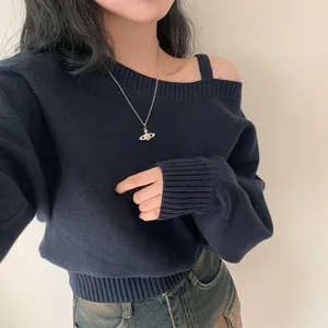 Dettaglio maglione in maglia blu scuro con scollo a barca e spalla scoperta da donna