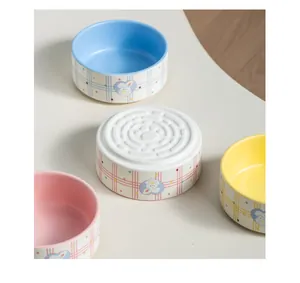 Detail view of colorful ceramic pet bowls with rabbit pattern and paw print bottom