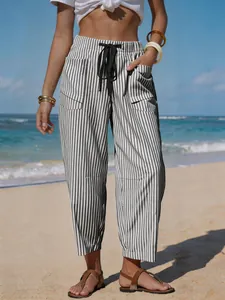 Detail of grey and white striped linen-like beach pants with drawstring and pockets