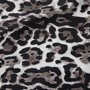 Close-up detail of leopard print fabric texture for high-waisted wide-leg trousers.