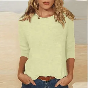 Detail showing the textured fabric and round neckline of the 3/4 sleeve yellow top