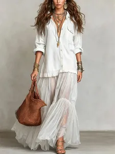 Full-length shot of a white bohemian retro denim-style maxi dress with chic pockets