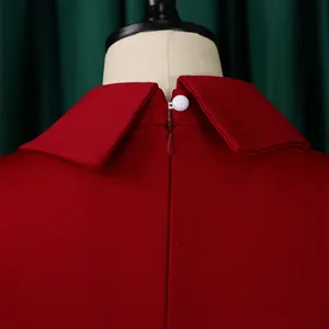 Close-up of red pencil dress neckline with white button and back zipper closure