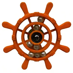 Close-up detail of an orange ship wheel toy for parrots featuring rolling white beads