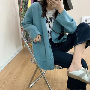 Oversized blue V-neck knit cardigan with pockets shown on a model in a casual setting