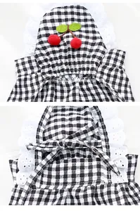 Detail view of a black and white gingham pet dress with cherry applique and lace