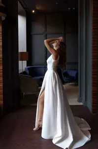 Side view of elegant French vintage white evening gown with high slit and backless design
