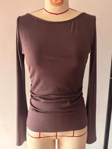 Detailopname van een nauwsluitend geribbeld shirt met boothals en rimpeldetails