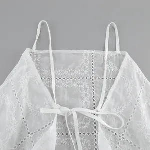 Gros plan d'un caraco brodé blanc avec des motifs délicats en dentelle ajourée chic