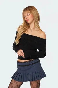 Elegant black off-the-shoulder ribbed knit sweater styled with a navy pleated skirt