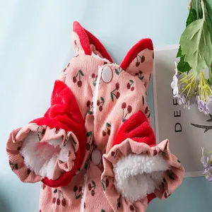 Close-up van roze corduroy hondenjas met kersenhoutprint en warme rode fleece voering