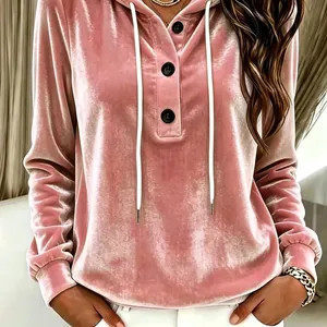 Detailed view of pink velvet drawstring hoodie with black buttons and soft fabric texture