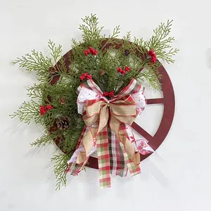 Détail d'une couronne de Noël rustique avec roue en bois, pommes de pin et nœud à carreaux