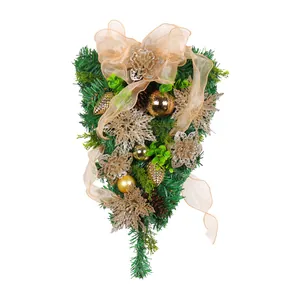 Elegant golden Christmas swag with pine needles, baubles and mesh ribbon for holiday decor