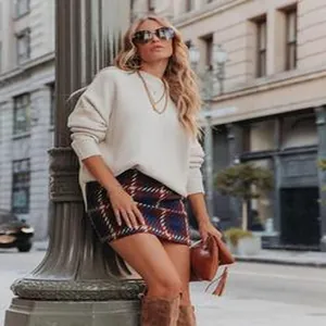 Lässiger herbstlicher Streetstyle mit weißem Strickpullover und kariertem Woll-Minirock