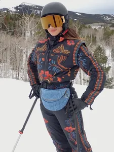 Close-up of a women's vintage floral embroidered ski jumpsuit in a snowy outdoor setting