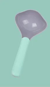 Primer plano de una pala bicolor para comida de mascotas con forma de rombo en verde