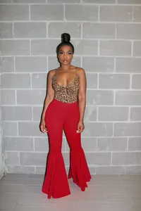 Mujer con body de leopardo y pantalones rojos acampanados de cintura alta con volantes