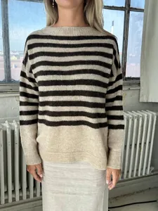 Vista detallada de un jersey de rayas de mujer oversize en un entorno acogedor