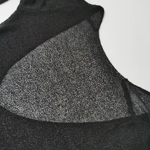 Detailed macro view of black sheer knitted fabric texture for sexy open back maxi dress