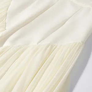 Close-up of white chiffon pleats and smooth fabric seam detail on suit