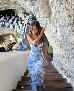 Detailed view of floral chiffon maxi dress in a scenic cave restaurant setting
