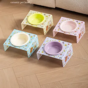 Detailed view of colorful ceramic pet bowls with patterned acrylic stands on wooden flooring