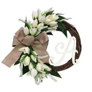 Detailed view of artificial white tulip wreath with personalized letter A and burlap bow