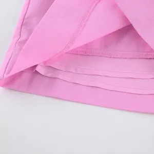 Gros plan sur un tissu en coton rose avec couture surjet professionnelle et doublure.