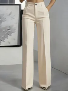 Front detail of high-waist cream suit trousers with elegant central crease and wide-leg cut.