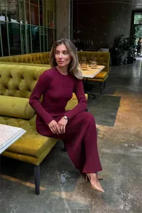 Elegant long sleeve burgundy ribbed knit maxi dress worn by model in a cafe setting