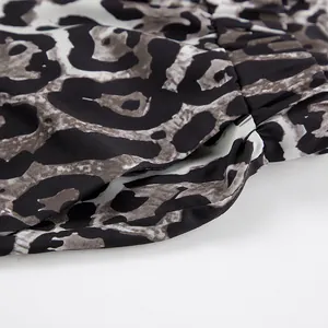 Detailed close-up showing side pocket and fabric texture of leopard print wide-leg pants