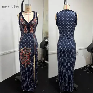 Robe longue élégante bleu marine sans manches à pois et fleurs avec fente latérale.