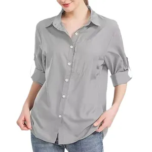 Detalle de la camisa gris con bolsillo de cremallera en el pecho y mangas remangadas