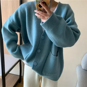 Close-up detail of a loose knit oversized cardigan with front pockets and V-neck.