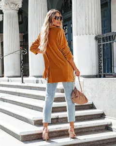 Back view of a fashionable mustard yellow velvet coat worn by a model in outdoor setting
