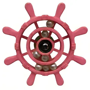 Close-up of pink parrot ship's wheel toy with rolling white beads inside.
