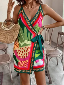 View of tropical print mini dress with wrap V-neckline and decorative bow at the waist