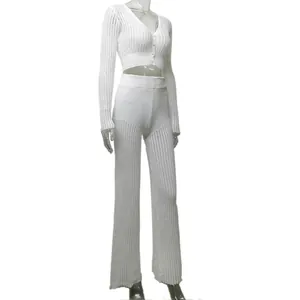 Detailed side view of a white hollow-out knit cardigan and high-waist pants set