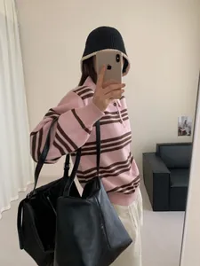 Pull chic en maille polo rayé rose et marron porté avec un grand sac cabas noir