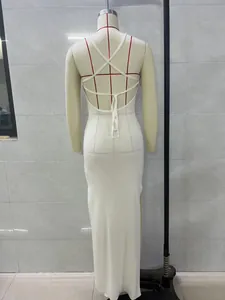 Back view of a white knitted maxi dress featuring elegant cross-straps and open back