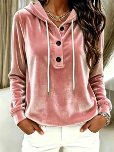Elegant close-up of a pink velvet hooded sweatshirt featuring drawstrings and button details