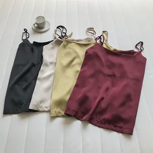 Quattro canottiere in raso di seta nero beige oliva e bordeaux su sfondo bianco
