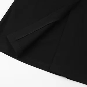 Detailed macro view of the professional hem stitching and side slit on an elegant black dress