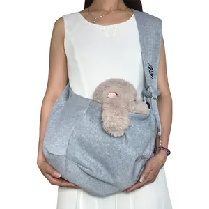 Comfortable gray cotton pet sling carrier bag worn by a model with a plush toy.