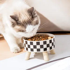 Moderne verhoogde keramische voerbak met dambordpatroon en houten poten voor katten