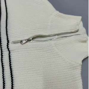 Detailed view of white striped knit sweater with silver half-zip collar and texture