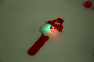 Detail shot of a glowing Santa Claus slap bracelet with red and green LED lights