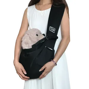 Model carrying a black crossbody pet sling bag with a small plush dog inside for travel