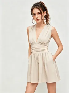 Eleganter beige Romper mit tiefem V-Ausschnitt, ärmellos, mit Wespentaille und Taschen.